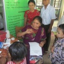 Volunteer assisting patients at a community allergy camp